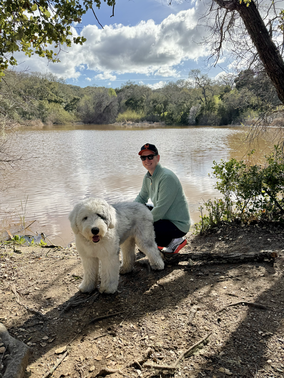 Ryan Bednar and his Old English Sheepdog Rondo by a lake